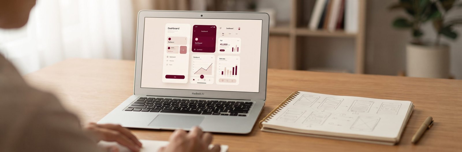 Laptop showing a simple business app beside wireframe sketches